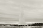 Geysir erupting with spectators close-by